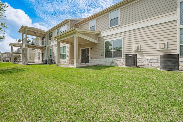 13600 Breton Ridge St Unit 22D, Houston, TX 77070 - rear view of house with central AC unit, a balcony, and stone siding