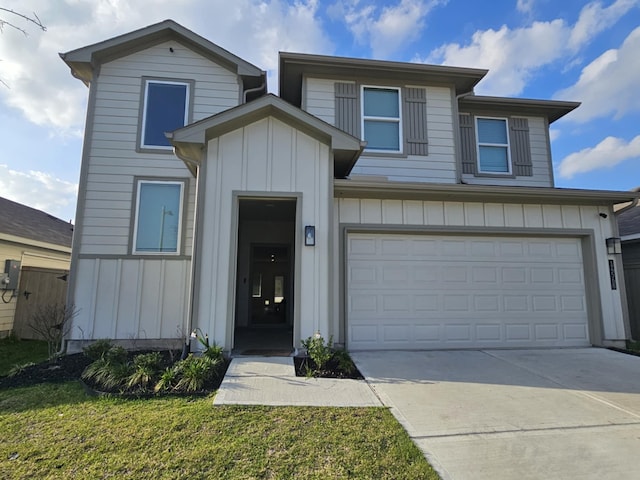 view of front of property with driveway, board and batten siding, a front yard, and an attached garage