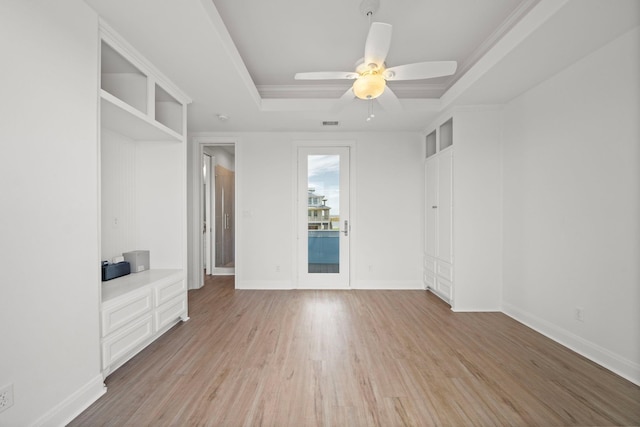 20919 W Sunset Bay Dr, Galveston, TX 77554 - unfurnished bedroom with a tray ceiling, light wood-style floors, and a ceiling fan