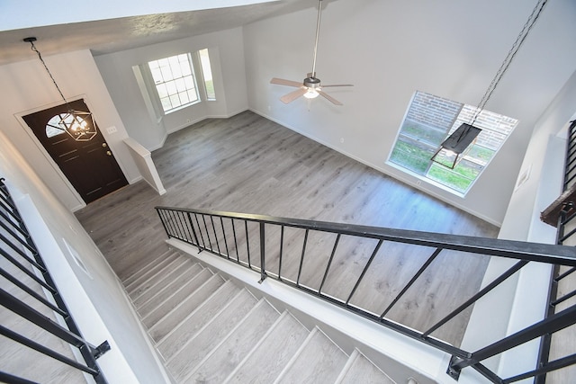 15827 Tammany Ln, Houston, TX 77082 - staircase with a towering ceiling, baseboards, wood finished floors, and ceiling fan