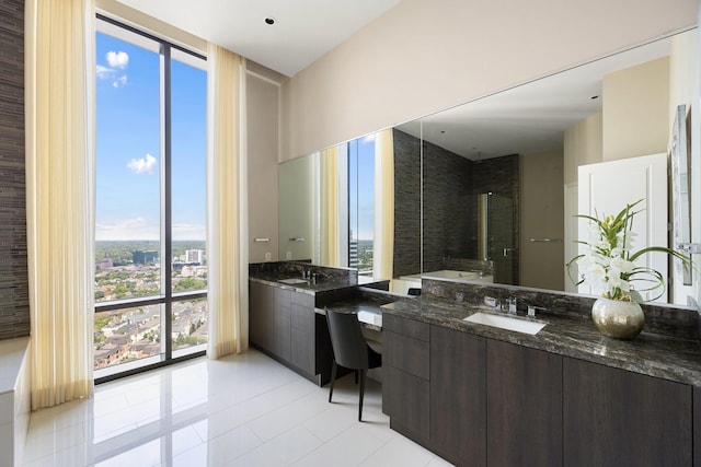 1409 Post Oak Blvd Unit 2702, Houston, TX 77056 - bathroom featuring two vanities, a sink, a tub to relax in, and floor to ceiling windows