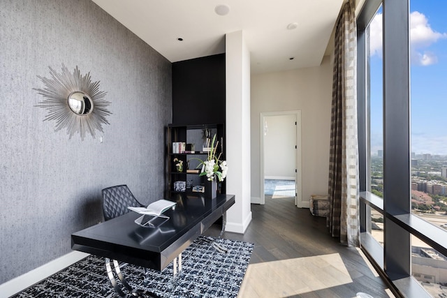 1409 Post Oak Blvd Unit 2702, Houston, TX 77056 - office with baseboards, wallpapered walls, an accent wall, a wall of windows, and wood finished floors