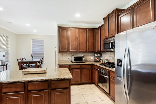 14711 E Ginger Spice Ct, Cypress, TX 77433 - kitchen featuring stainless steel appliances, tasteful backsplash, ornamental molding, light stone counters, and light tile patterned floors