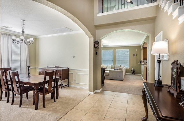 14711 E Ginger Spice Ct, Cypress, TX 77433 - dining space featuring light carpet, arched walkways, a chandelier, ornamental molding, and light tile patterned floors