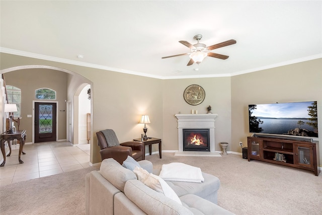 14711 E Ginger Spice Ct, Cypress, TX 77433 - living room featuring arched walkways, light carpet, a glass covered fireplace, a ceiling fan, and ornamental molding