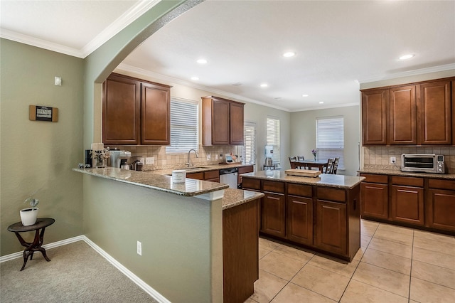 14711 E Ginger Spice Ct, Cypress, TX 77433 - kitchen with stainless steel dishwasher, a kitchen island, light stone countertops, decorative backsplash, and arched walkways