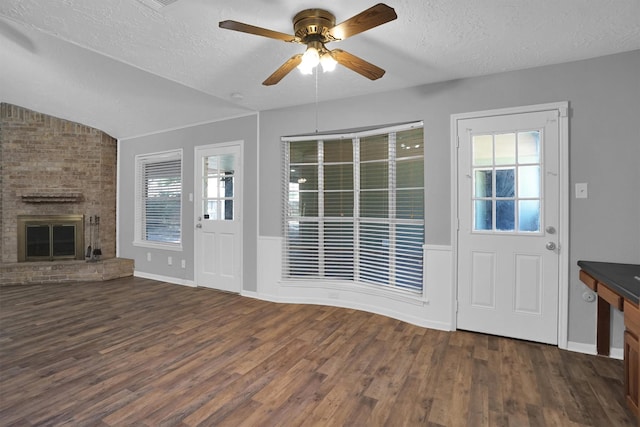 9611 Huntington Hill Dr, Houston, TX 77099 - unfurnished living room featuring a textured ceiling, lofted ceiling, dark wood-type flooring, ceiling fan, and a brick fireplace