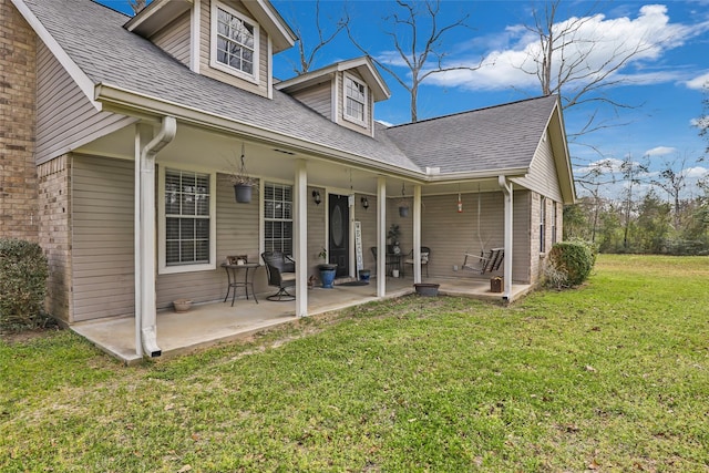 2585 State Highway 150, Coldspring, TX 77331 - back of house with a yard, a shingled roof, and a patio area