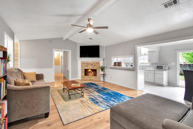 3306 Brookdale Dr, Houston, TX 77339 - living area with ceiling fan, a fireplace, light wood-style flooring, and visible vents