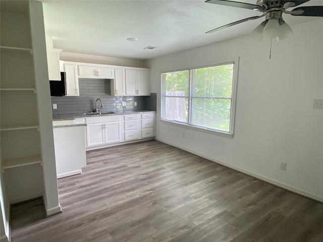 5217 Malmedy Rd A/B, Unit A/B Houston, TX 77033 - kitchen featuring white cabinetry, backsplash, light wood-type flooring, and ceiling fan