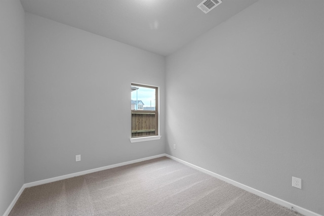 empty room featuring visible vents, baseboards, and carpet floors