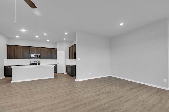 unfurnished living room with light wood-style flooring, baseboards, a ceiling fan, and recessed lighting