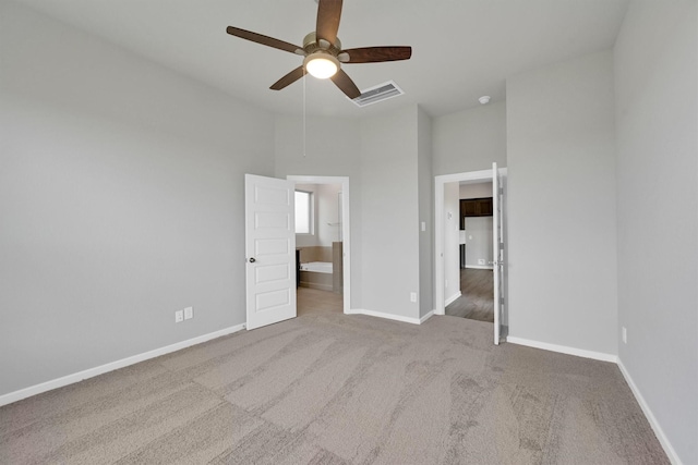 unfurnished bedroom with visible vents, baseboards, ceiling fan, carpet, and ensuite bath