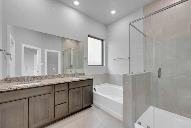 full bathroom with a shower stall, double vanity, a bath, and a sink