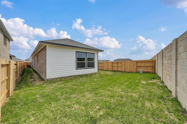exterior space with a fenced backyard and a lawn