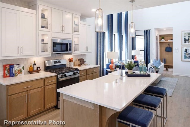 3314 Verdant Ln, Richmond, TX 77406 - kitchen with stainless steel appliances, a breakfast bar, decorative backsplash, light countertops, and recessed lighting