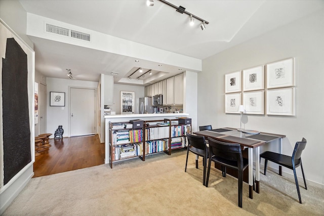 dining room with baseboards, visible vents, light carpet, and rail lighting