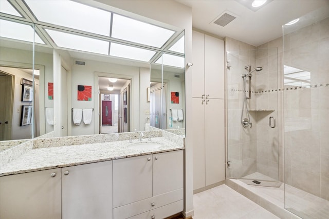 full bathroom featuring visible vents, a shower stall, tile patterned flooring, and vanity