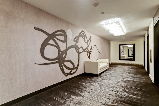 hallway featuring baseboards and dark wood-type flooring