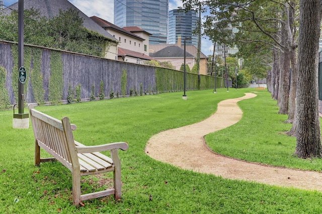 view of community featuring a lawn and fence