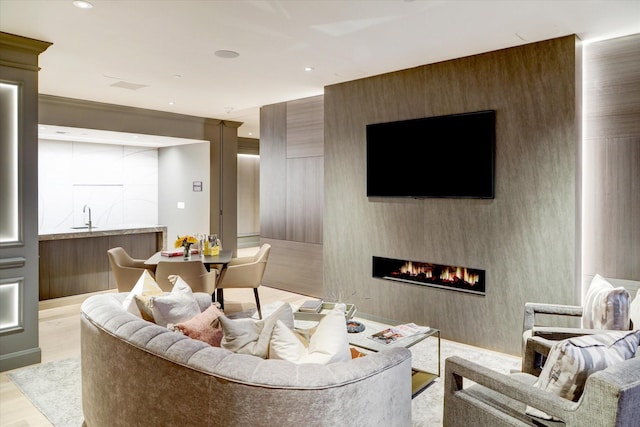 living area featuring wood finished floors, a large fireplace, and recessed lighting