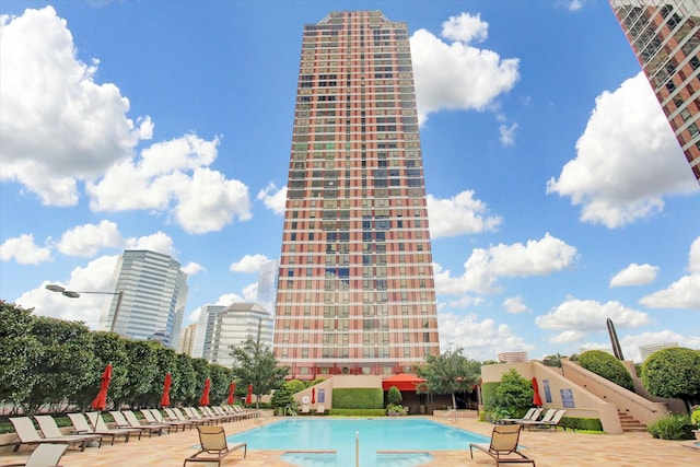 community pool featuring a patio and a view of city