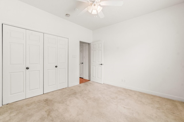 unfurnished bedroom featuring a closet, a ceiling fan, carpet, and baseboards