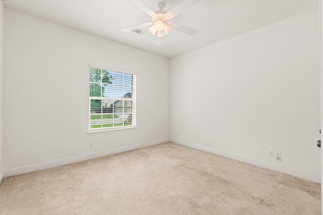 empty room featuring baseboards, light colored carpet, ceiling fan, and visible vents