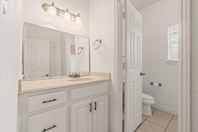 bathroom with toilet, baseboards, tile patterned flooring, and vanity