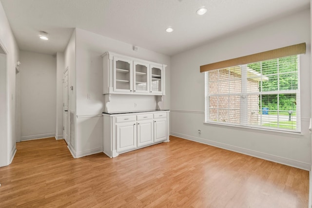 104 Mccardell Ln, Livingston, TX 77351 - kitchen featuring white cabinets, baseboards, glass insert cabinets, and light wood-style floors