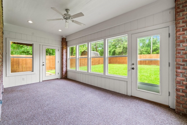 unfurnished sunroom featuring ceiling fan
