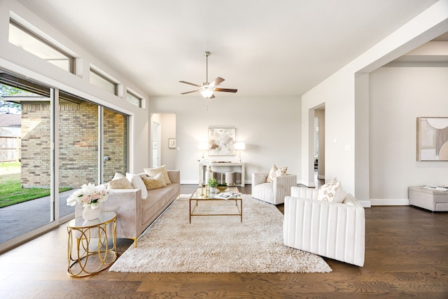 living room with baseboards, wood finished floors, and ceiling fan