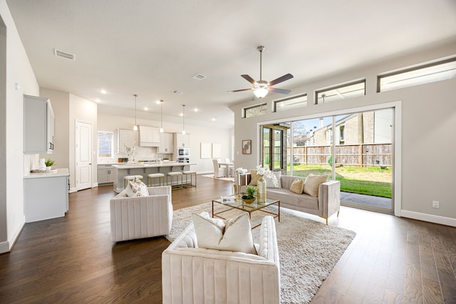 living room featuring visible vents, baseboards, ceiling fan, recessed lighting, and dark wood-type flooring