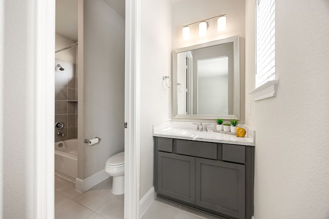 bathroom featuring baseboards, toilet, tile patterned floors, vanity, and shower / washtub combination