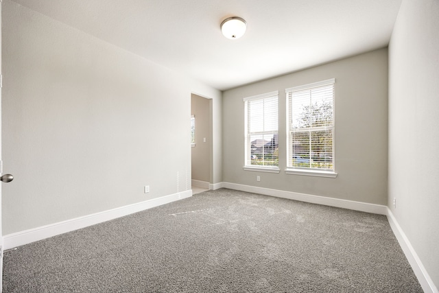 empty room with baseboards and carpet flooring