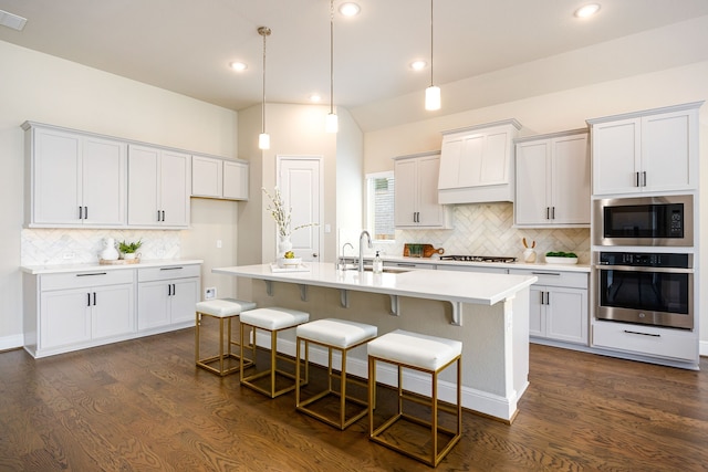 kitchen with light countertops, gas cooktop, stainless steel oven, a sink, and built in microwave