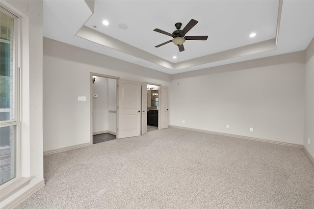4510 Sanctuary Trails Dr, Spring, TX 77388 - unfurnished bedroom featuring a tray ceiling, light carpet, baseboards, recessed lighting, and ensuite bath