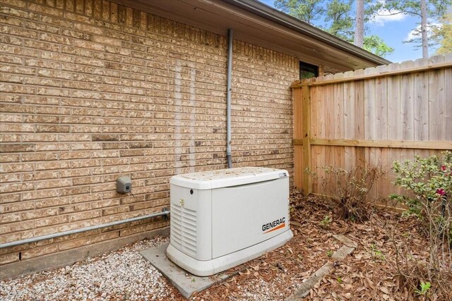 exterior details featuring brick siding, fence, and a power unit