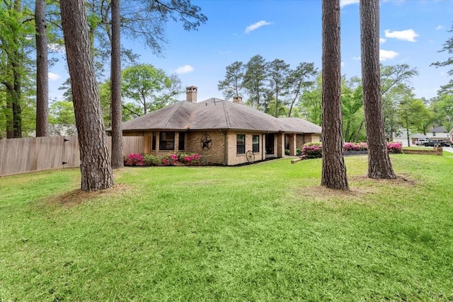 view of front of home with a front lawn, fence, and a chimney