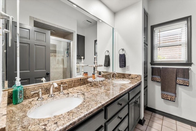 bathroom featuring tile patterned flooring, a sink, a stall shower, and double vanity