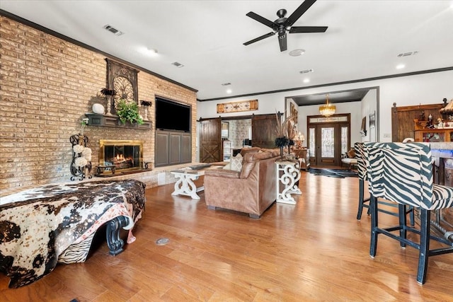 living room featuring crown molding, visible vents, french doors, and wood finished floors
