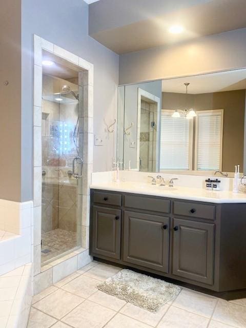 full bath featuring a notable chandelier, vanity, tile patterned floors, a bath, and a stall shower