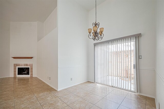 13322 Chaston Dr, Houston, TX 77041 - unfurnished living room with a towering ceiling, tile patterned floors, a chandelier, baseboards, and a tile fireplace