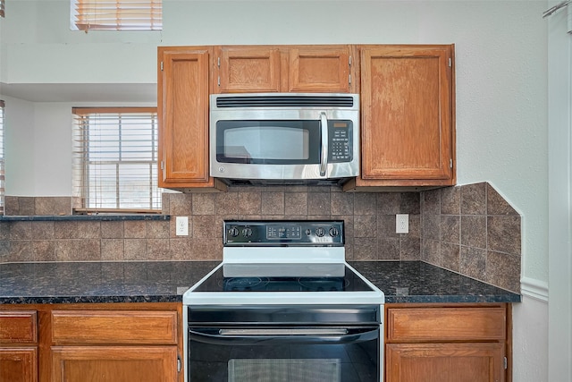 13322 Chaston Dr, Houston, TX 77041 - kitchen with stainless steel microwave, electric stove, decorative backsplash, and dark stone counters