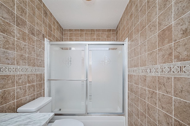 13322 Chaston Dr, Houston, TX 77041 - bathroom featuring tile walls, bath / shower combo with glass door, and toilet