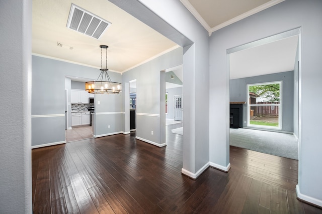 14507 Heron Marsh Dr, Cypress, TX 77429 - unfurnished dining area with a chandelier, a fireplace, dark wood-style floors, crown molding, and baseboards