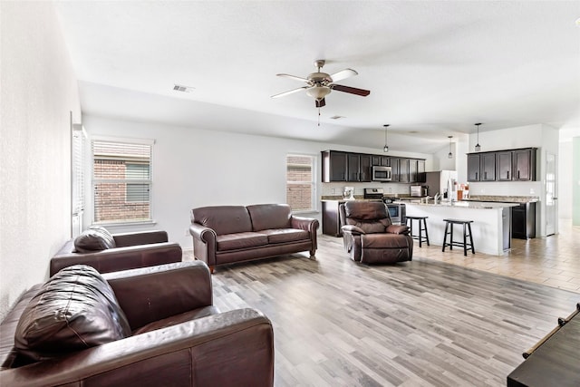 22911 Eselle Creek Dr, Tomball, TX 77375 - living area with plenty of natural light, a ceiling fan, and light wood-style floors