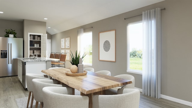 dining room with baseboards, lofted ceiling, recessed lighting, and light wood finished floors