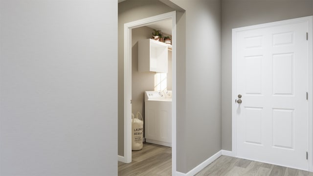 corridor featuring baseboards and light wood-style floors