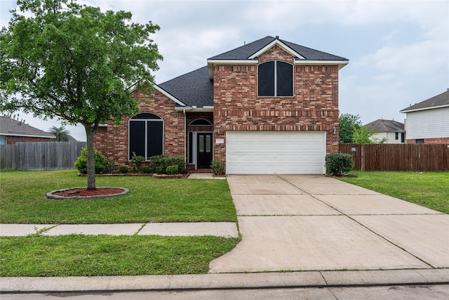 view of front of house featuring a front yard, fence, and a garage